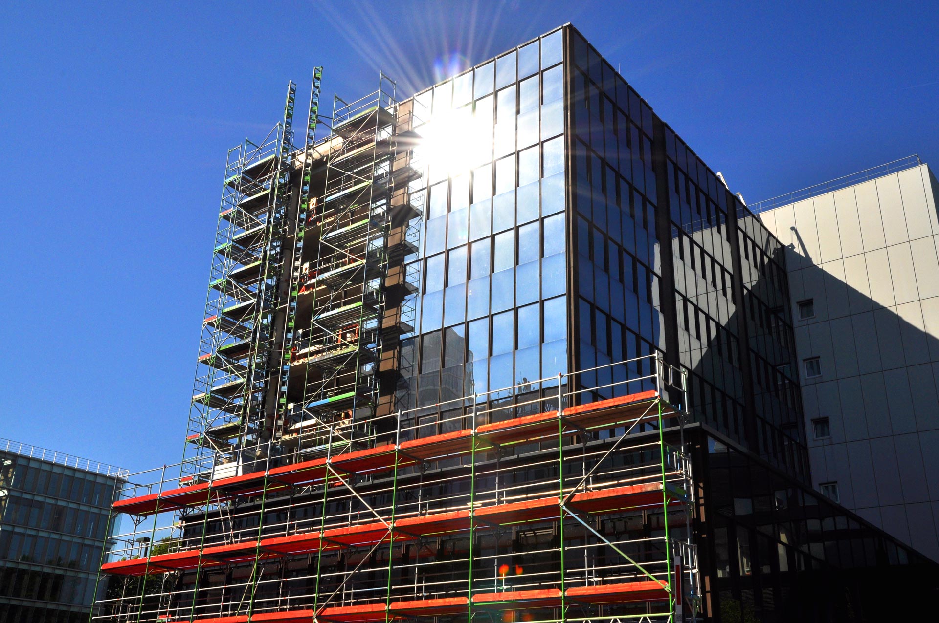 Fassadengerüst mit Bauaufzug an modernem Bürogebäude in Düsseldorf während einer Fassadensanierung